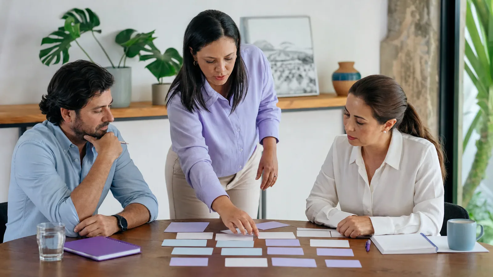 Dos gerentes comparan prioridades de desarrollo del personal con una facilitadora de recursos humanos.