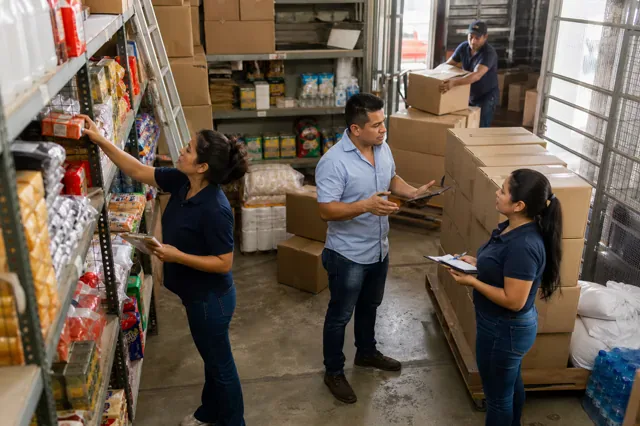 Owner coordinates inventory, staffing, and a delivery in the shop.