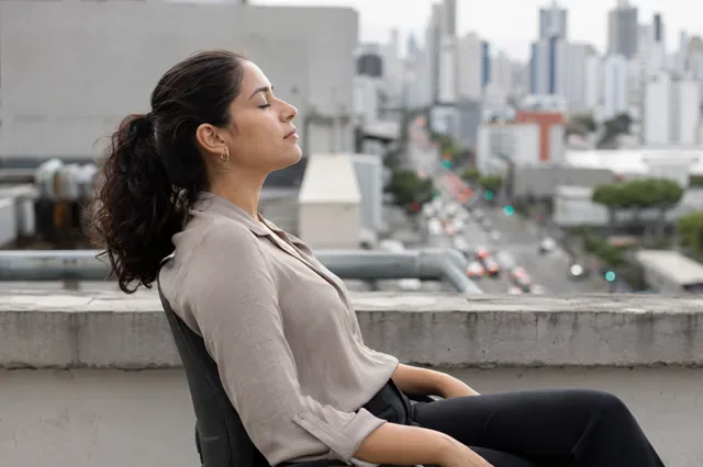 Employee practices mindful breathing during a rooftop break.