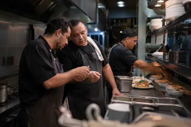 Kitchen team reorganizes an order after a high-pressure situation.
